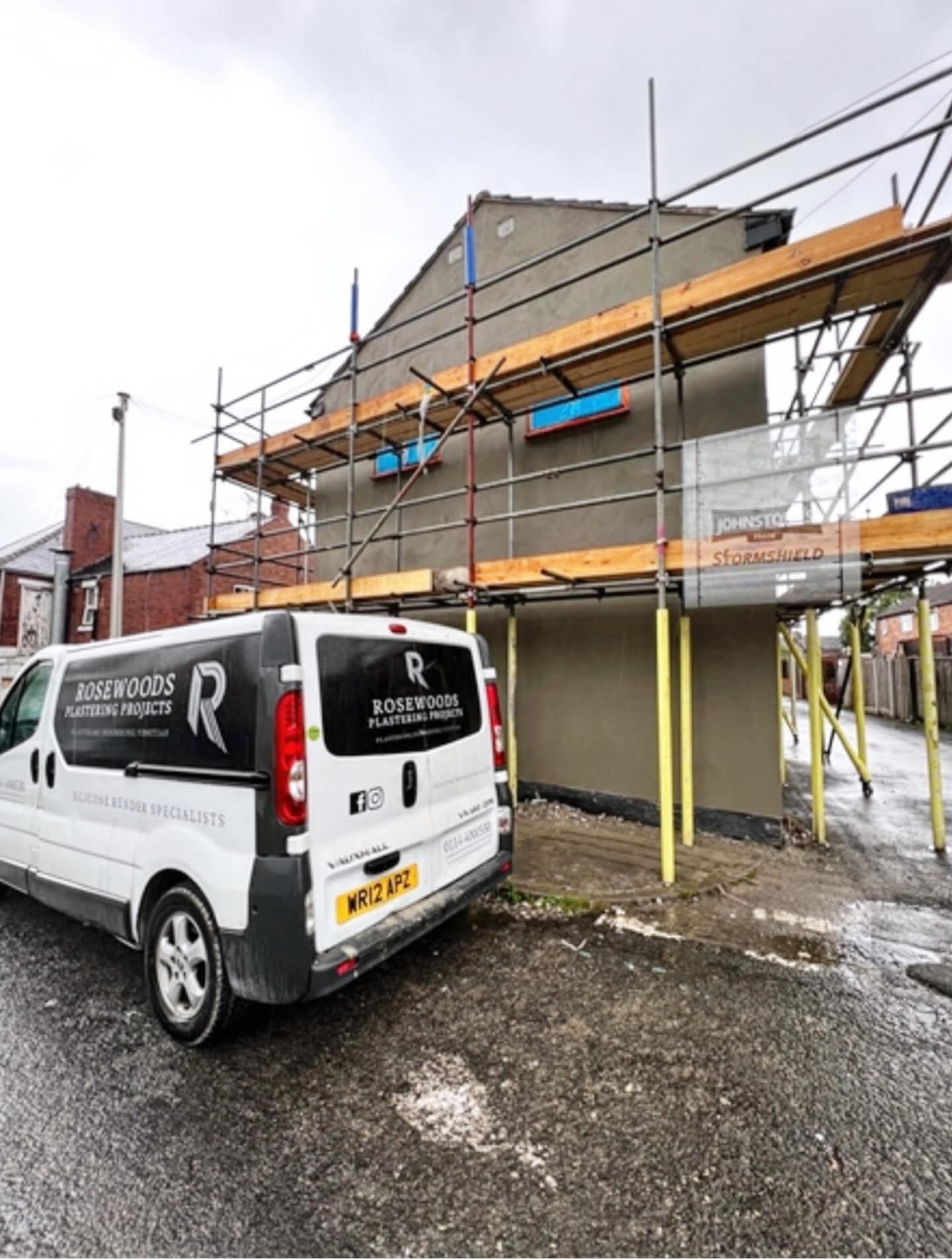 The Rosewoods team van on site in front of a freshly rendered, scaffolded home